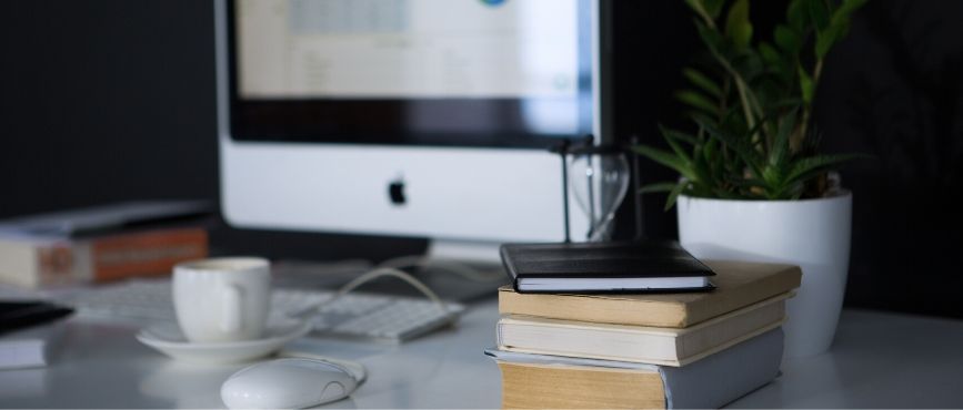 computer for searching eresources with a stack of books and a mug